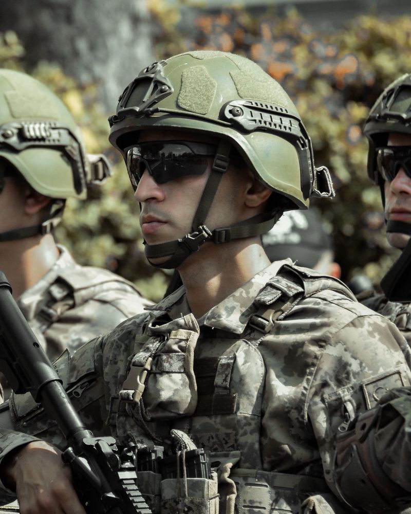 Militares em formação, com capacete tático e óculos de proteção.
